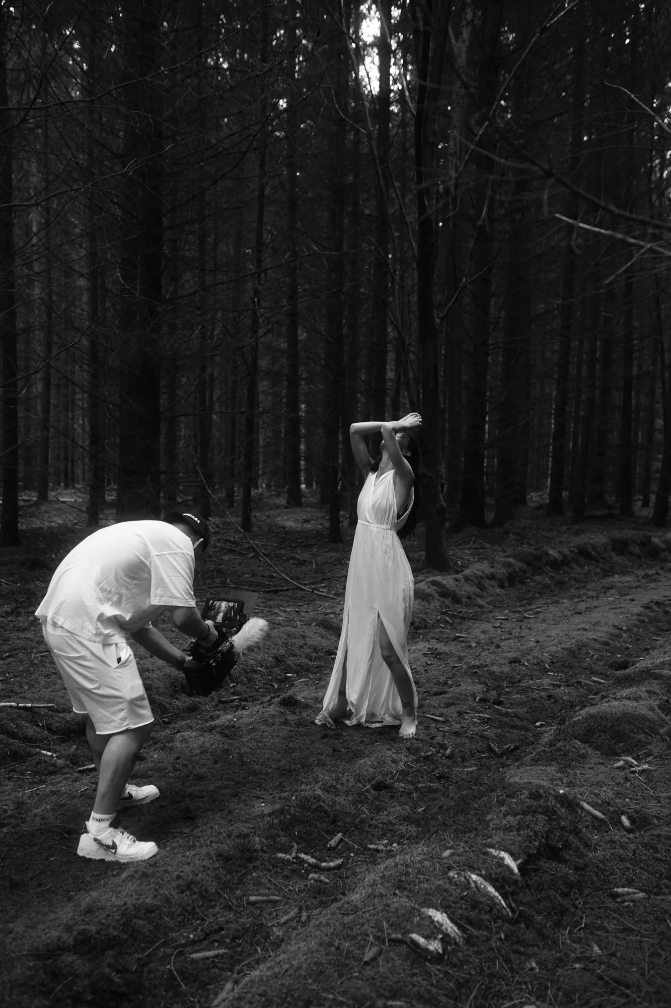 Dreh im Wald: Lucas geht mit der Kamera in die Knie, davor eine Frau im weißen Kleid